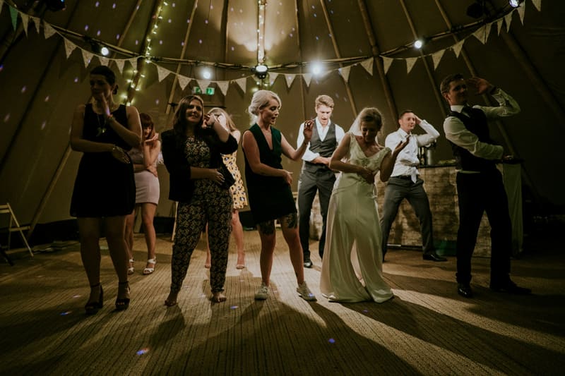 Guests of different ages dancing at an evening wedding reception